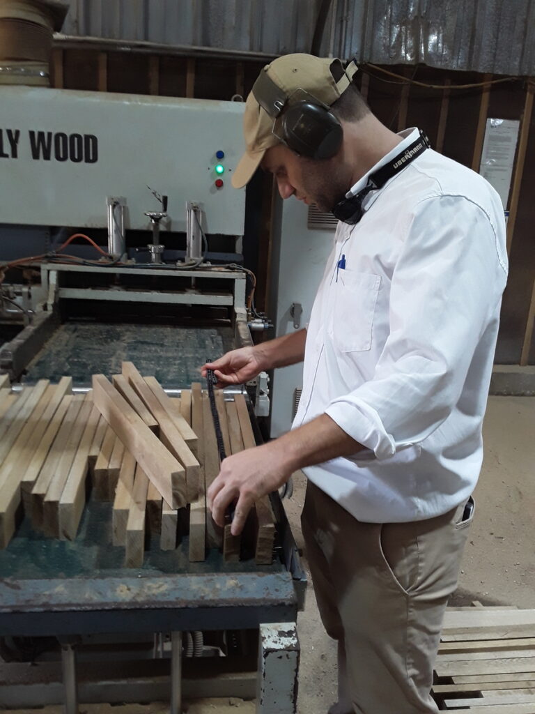 worker checking product dimensions in a sawmill